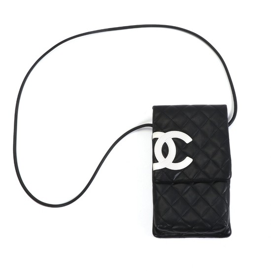 Chanel: A bag of quiltet black calf skin, white “CC” logo, shoulder strap of black leather, one large compartment and a small compartment.