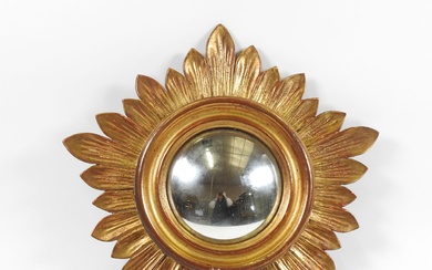 Miroir circulaire dit "de sorcière" en bois doré, le pourtour à décor de feuilles. 35,5...