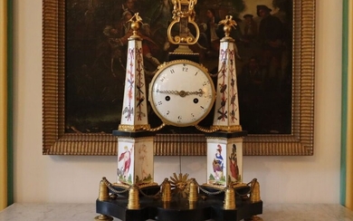 Pendule-portique en marbre, porcelaine et bronze doré formée de deux obélisques, décor polychrome de divinités...