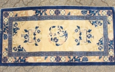 A CHINESE WOOL RUG with three central motifs in blue