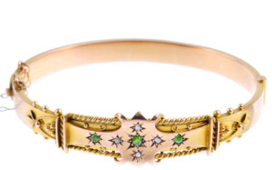 An Edwardian 9ct gold demantoid garnet and diamond hinged bangle. View more details