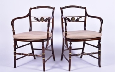 A pair of Regency style stained oak armchairs each with caned seats, applied brass collars and plaques to the twisted...
