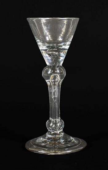A Cordial Glass, circa 1710, the wide conical bowl with basal air tear on an inverted baluster stem