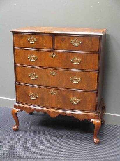 A George III walnut bow front chest of two short over three graduating long drawers on later pad
