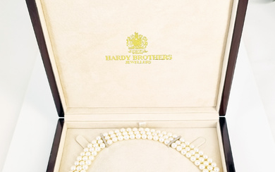 A HARDY BROTHERS CULTURED PEARL NECKLACE WITH SAPPHIRE AND DIAMOND CLASP: three rows of 55