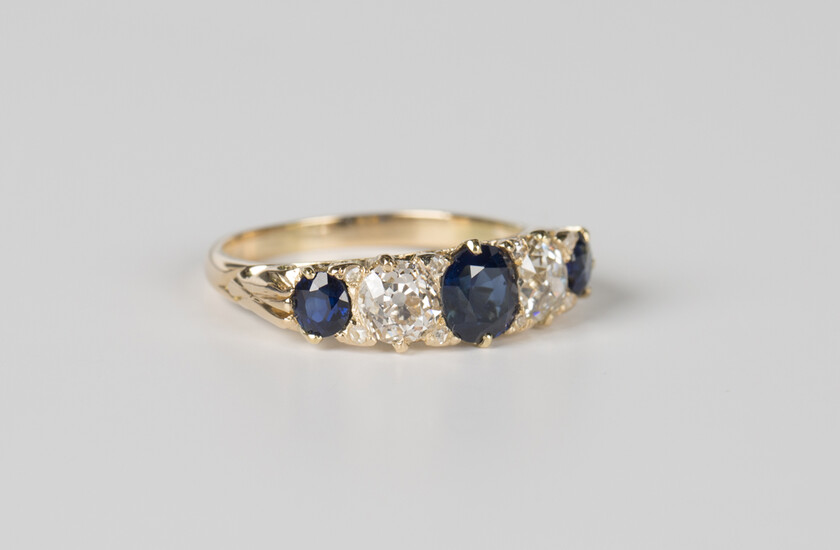 A gold, sapphire and diamond five stone ring, mounted with three cushion cut sapphires alternating w