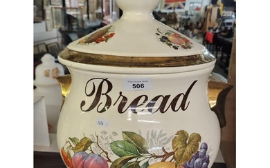 A large ceramic bread bin with pictures of fruit and gilt co...