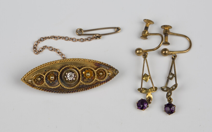 A late Victorian gold and diamond single stone brooch of boat shape form, mounted with a cushion sha