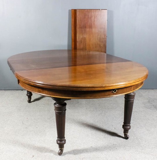 A mahogany circular extending dining table, Late Victorian, with...