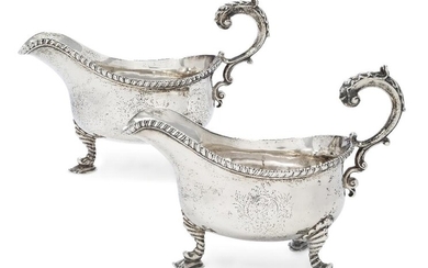 A pair of George II silver gravy boats, London, 1759, William Skeen, each with flying triple scroll handle to gadrooned rim and raised on three moulded legs terminating in shaped pad feet, 16cm high, 22.7cm long (inc. handles), total weight approx...