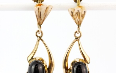 A pair of yellow metal (tested minimum 9ct gold) screw back fitted drop earrings set with cabochon cut black star sapphires, L. 3.5cm.