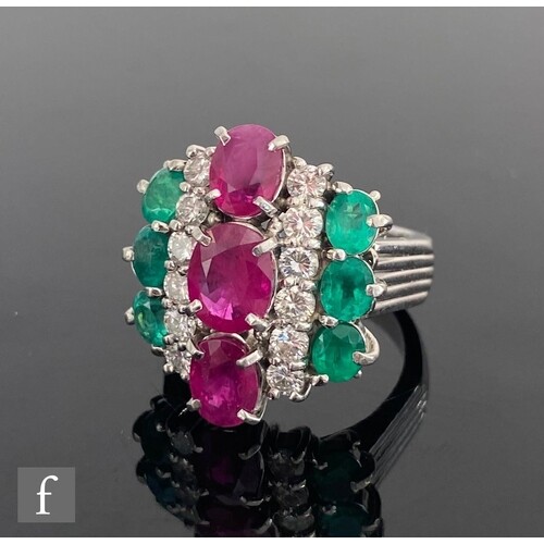 A platinum (900) emerald, diamond and ruby vertically set Ar...