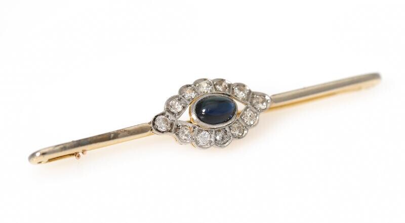 NOT SOLD. A sapphire and diamond brooch set with a synthetic sapphire encircled by numerous diamonds, mounted in 18k gold and platinum. L. app. 6.2 cm. – Bruun Rasmussen Auctioneers of Fine Art