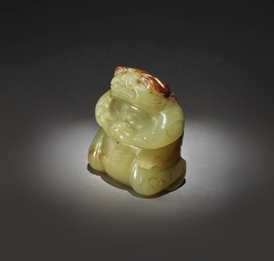 AN EXCEPTIONALLY RARE YELLOW AND RUSSET JADE FIGURE OF A MYTHICAL TOAD SIX DYNASTIES