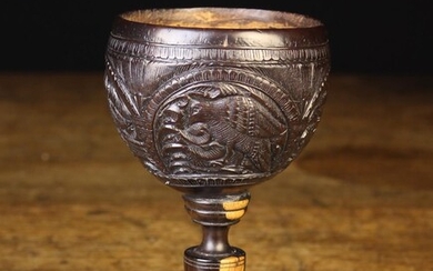 An 18th Century Coconut Shell Tumbler or Stirrup Cup. The intricately decorated bowl having four arc
