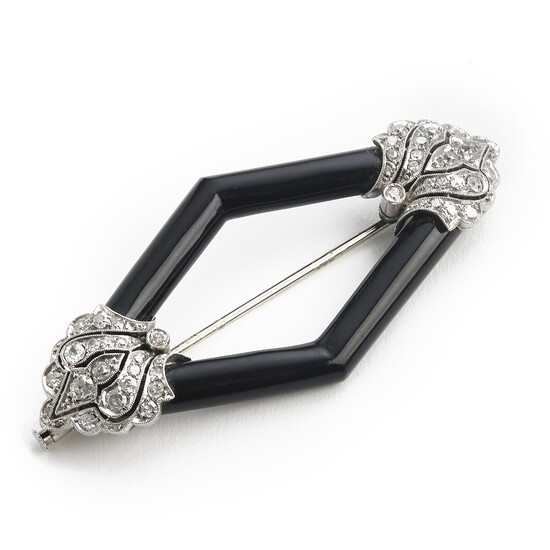 An Art Deco onyx and diamond brooch set with carved black onyx and numerous old and single-cut diamonds, mounted in platinum. L. app. 6.4×2.9 cm.