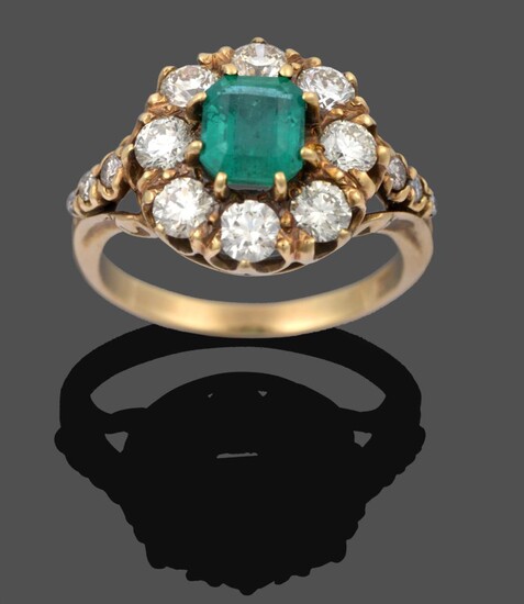 An Emerald and Diamond Cluster Ring, the emerald-cut emerald within a border of round brilliant cut