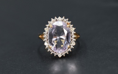 An amethyst and diamond cluster ring, the central oval cut amethyst measuring approximately 13.2 L x