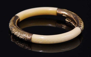 An early 20th century Chinese carved ivory and gold mounted hinged bangle