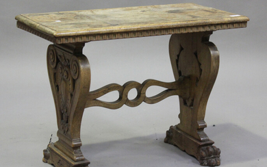 An early 20th century Italian walnut occasional table, raised on twin supports carved with shields