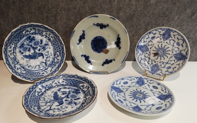 Chine, Lot de cinq assiettes en porcelaine blanc/bleu. Une à décor d’idéogramme signée au centre,...