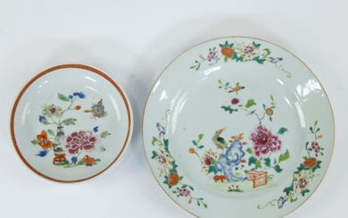 Chinese famille rose dinner plate and a smaller dish, the plate decorated with garden decor, an exotic bird perched on a pierced blue rock, the rim with pomegrantaes and peony branches, Qianlong period