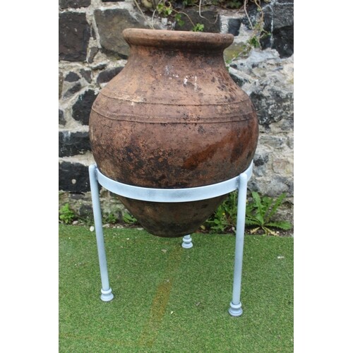 Early 1900's olive pot mounted on a black wrought iron stand...