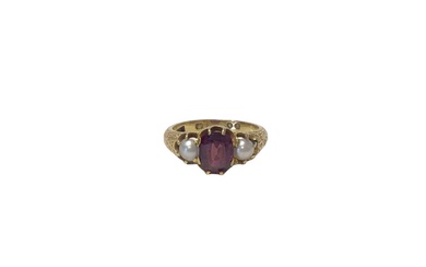 Early Victorian gold garnet and pearl three stone ring, the central oval mixed cut garnet flanked by two half pearls in claw setting with engraved foliate shoulders (London 1856). Ring size N½