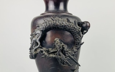 JAPON. VASE en bronze à patine brune à décor en relief du dragon chassant la...