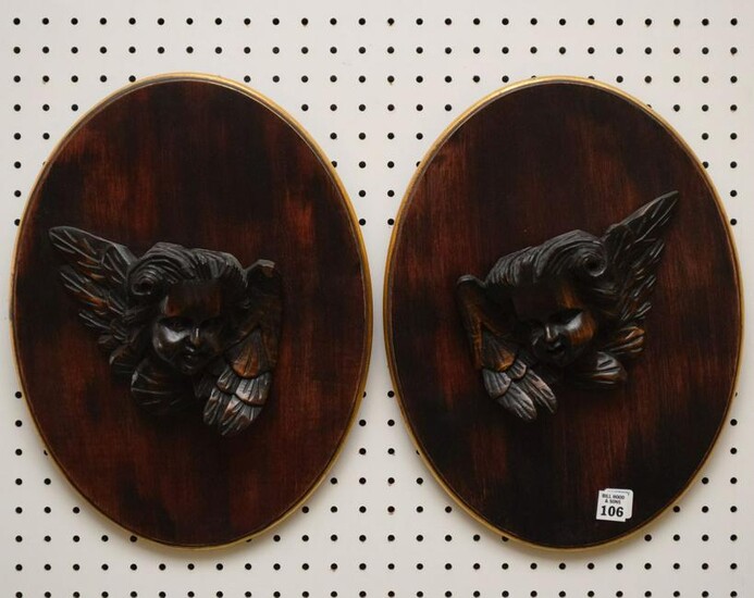 Pair Carved Angel Heads mounted on oval mahogany