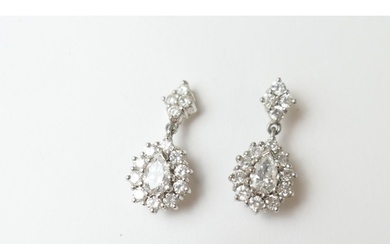 Pair of diamond cluster pendant earrings, each centred with ...