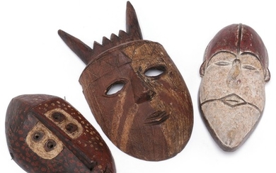 Three masks of carved patinated wood with traces of red, white and black pigment. Lega style etc. H. 24–32 cm. (3)