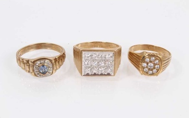 Two 9ct gold rings set with synthetic white stones and one other 9ct gold blue stone ring, all with textured shoulders on 9ct yellow gold shanks (3)