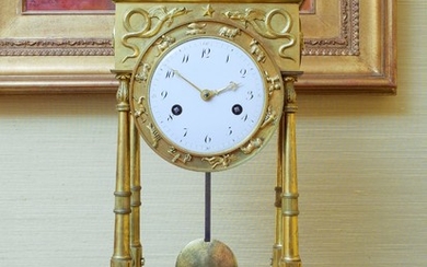 Pendule portique d'époque Empire en bronze ciselé et doré à décor d'animaux et palmettes, 39x23x15 cm