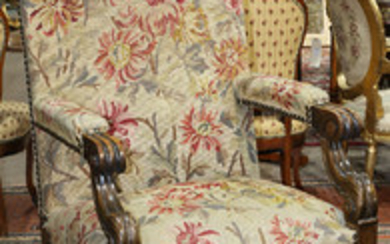 Continental fireside chair, 19th century, having a needlepoint upholstered seat and back accented with brass nail head trim, and ris...