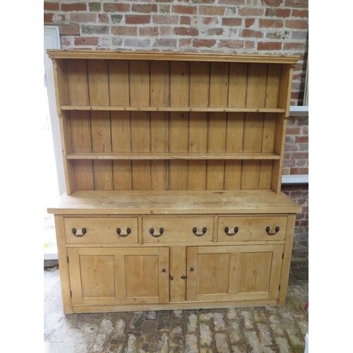 A 19th century stripped pine dresser with an open rack top a...