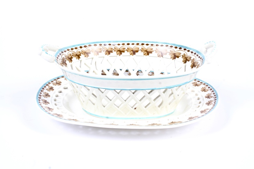 A Davenport creamware oval two-handled basket and stand, circa 1800. With impressed marks, painted in sepia with vine and bead pattern pierced borders below green line (damages and restoration), 23.5cm wide