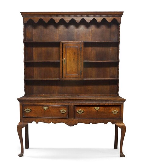 A George III oak dresser, Circa 1790, the superstructure with top shelf above central cupboard door, flanked by further shelves, the base with two drawers, raised on cabriole legs to pad feet, 196cm high, 142cm wide, 47cm deep