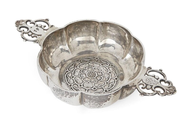 A George V silver porringer with Tudor rose design to base, London, 1929, J. Parkes & Co., the lobed, planished sides to pierced scrolling handles, one engraved 'YF', 19.5cm wide (inc. handles), 3.7cm high, approx. weight 7.2oz
