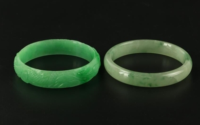 A Pair of Green Jadeite Bangle Bracelets, One Carved