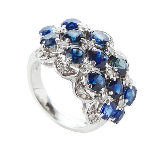A SAPPHIRE AND DIAMOND DRESS RING IN 18CT WHITE OLD, COMPRISING THIRTEEN BLUE SAPPHIRES TOTALLING 6.30CTS, SPACED WITH ROUND BRILLI...