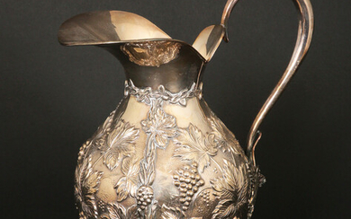 A SPANISH SILVER WATER JUG REPOUSEE GRAPES AND LEAVES