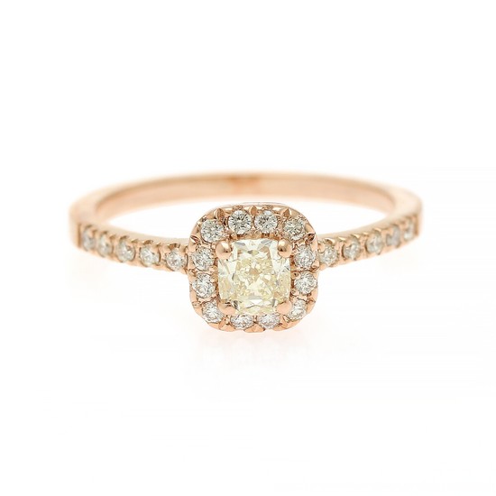 A diamond ring set with a cushion-cut diamond encircled by numerous brilliant-cut diamonds, mounted in 14k rose gold. Size 53.