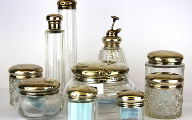 A group of nine hallmarked silver topped dressing table items, together with a cut crystal atomizer.