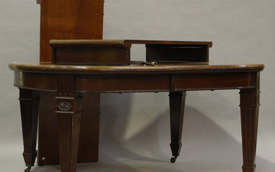 A large Edwardian mahogany extending dining table, the top with two extra leaves above a fluted frie