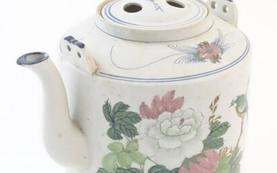 A large Oriental teapot decorated with flowers, foliage