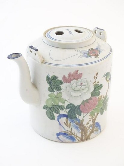 A large Oriental teapot decorated with flowers, foliage