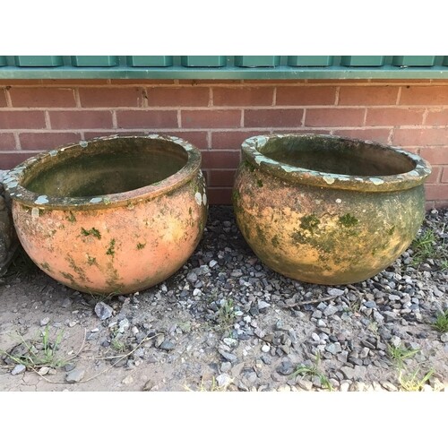 A large pair of circular terracotta planters.