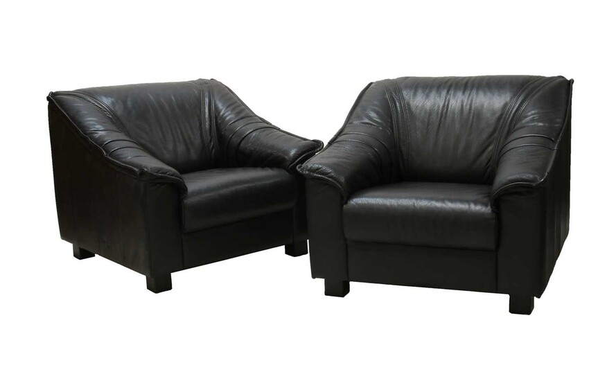 A pair of black leather armchairs