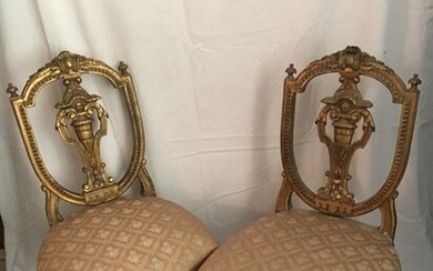 A pair of carved and gilded wooden chairs,...